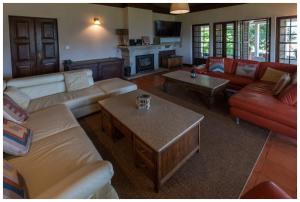 un salon avec des canapés, des tables et une cheminée dans l'établissement Alojamento Estrela Cottage, à Torrozelo