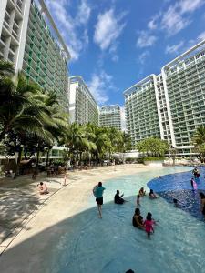 un grupo de personas en una piscina en un complejo en Bellescapes - Azure Resort (1 BR with Balcony), en Manila