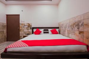 a bedroom with a large bed with red pillows at Hotel Holiday Rani Gunj Opp Punjab national bank in Secunderabad
