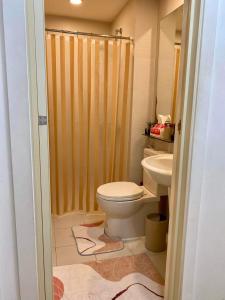 y baño con aseo y lavamanos. en Bellescapes - Azure Resort (1 BR with Balcony), en Manila