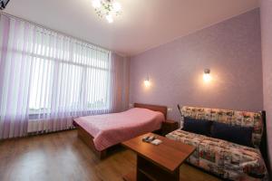 a hotel room with a bed and a couch at Guest House Voyazh ГОСТЕВОЙ ДОМ "ВОЯЖ" in Livadiya
