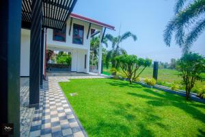 una casa con césped delante en Sri Lanka villa DSR , Wennappuwa, en Wennappuwa