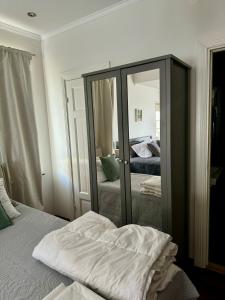 格蘭納的住宿－Hills Cottage，卧室内的镜子,配有床