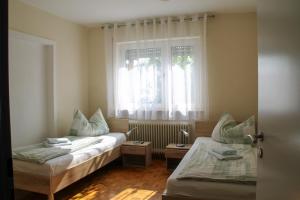 1 dormitorio con 2 camas y ventana en Ferienwohnung Noll en Alzenau in Unterfranken