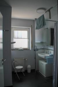 a bathroom with a sink and a toilet and a window at Ferienwohnung Noll in Alzenau in Unterfranken