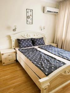 um quarto com uma cama grande e lençóis azuis em Sarafovo D&V Apartments em Burgas