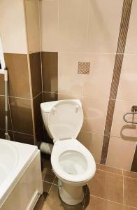 uma casa de banho com um WC branco e um lavatório. em Sarafovo D&V Apartments em Burgas