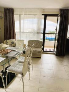 uma sala de estar com uma mesa e cadeiras e um sofá em Sarafovo D&V Apartments em Burgas