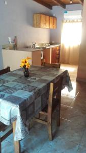a kitchen with a table with a vase of flowers on it at LAPACHO II in Puerto Leoni