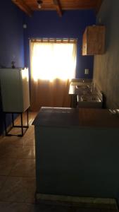 a kitchen with a window with the light shining through at LAPACHO II in Puerto Leoni