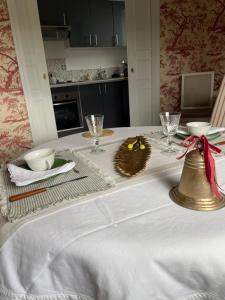 a dining room table with a white table cloth and a bell at Belle Fontaine in Bourges