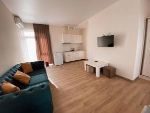 a living room with a green couch and a table at GG ApartHotel in Batumi