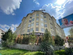 un gran edificio bronceado con un cartel en él en Cozy apartment, en Samarkand