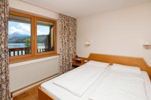 a bedroom with a white bed and a window at Appartement-Hotel Seespitz in Füssen