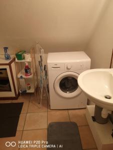 ein Badezimmer mit einer Waschmaschine und einem Waschbecken in der Unterkunft Studio entier in Sens