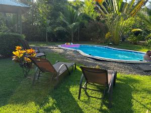 un patio con 2 sillas y una piscina en Casa Mediterranea Uvita Oasis with Villa Cabins and Apartment, en Uvita