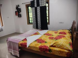a bedroom with a bed with a yellow blanket at Munnar Village Homes in Munnar