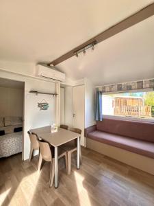 Habitación con mesa, sillas y cama en Mobil Home Abricotiers 1 en Valras-Plage