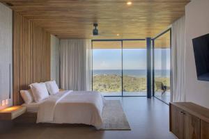 a bedroom with a bed and a view of the ocean at Casa Con Vista – Nosara, Guanacaste, Costa Rica. S in Nosara