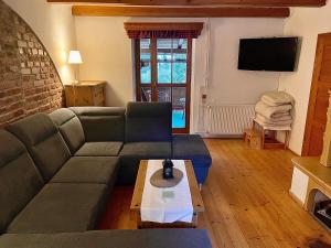 uma sala de estar com um sofá e uma mesa em Apartmány Chalupinka em Železná Ruda