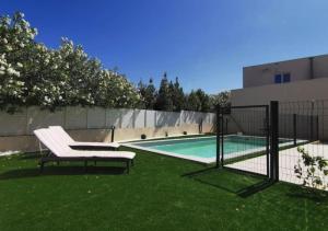 une clôture avec un banc à côté d'une piscine dans l'établissement Villa avec Piscine • Plage 15’, à Béziers