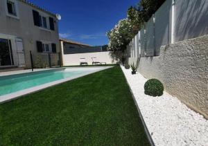 une arrière-cour avec une piscine et une maison dans l'établissement Villa avec Piscine • Plage 15’, à Béziers