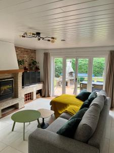 a living room with a couch and a fireplace at Beach Bungalow Green in Middelkerke