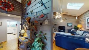 a living room with a blue couch and a wall with fish magnets at OCEAN RETREAT home in Jekyll Island