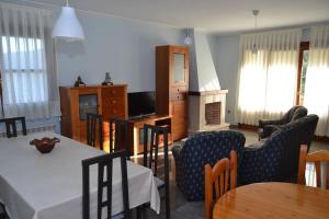 a living room with a table and chairs at Casa Manuela LLanes Asturias. in Pendueles