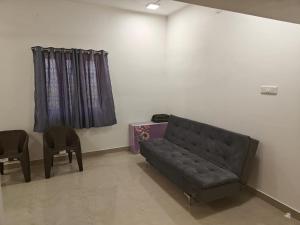 salon z kanapą i 2 krzesłami w obiekcie Thirunallar Treva Homes w mieście Karajkkal