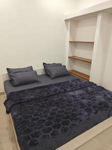 sypialnia z dużym łóżkiem z czarną pościelą i poduszkami w obiekcie Thirunallar Treva Homes w mieście Karajkkal