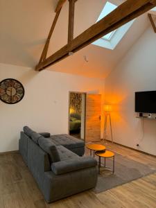 a living room with a couch and a tv at le chalet d Alex in Étretat