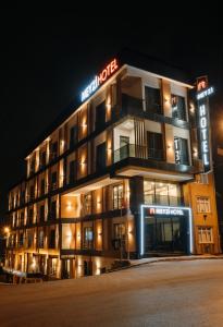 a hotel building with a neon sign in the night at Meyzi Hotel in Istanbul