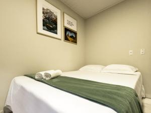 ein Schlafzimmer mit einem Bett mit zwei gewalzten Handtüchern darauf in der Unterkunft Casa com visão panorâmica no centro de Nova Trento in Nova Trento