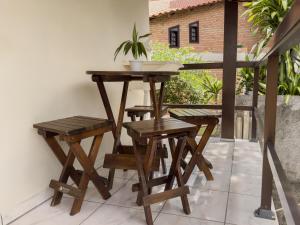 einen Holztisch und Hocker auf einer Terrasse in der Unterkunft Casa com visão panorâmica no centro de Nova Trento in Nova Trento