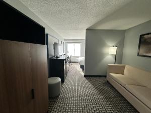 a hotel room with a couch and a bed at AmericInn by Wyndham Reedsburg in Reedsburg