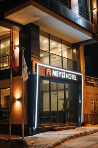 un cartello di un hotel di fronte a un edificio di notte di Meyzi Hotel a Istanbul