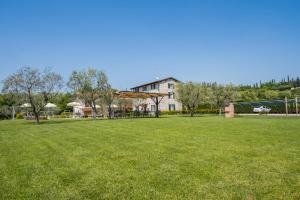 un grande prato con un edificio sullo sfondo di Agriturismo Le Ginestre a Lazise