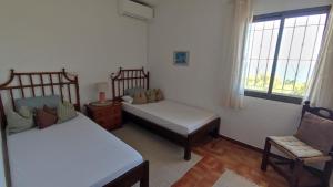 a bedroom with two beds and a chair and a window at Casa Alberto - Altea in Altea +38 photos