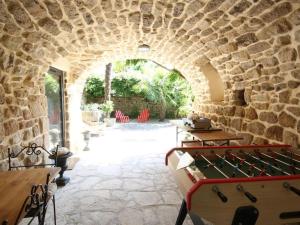 un arco de piedra con mesa de ping pong en La Salamandre, en Lablachère