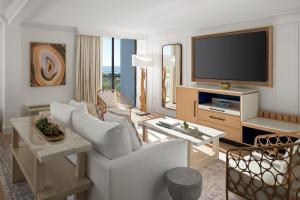 a living room with a white couch and a television at Sheraton Sand Key Resort in Clearwater Beach