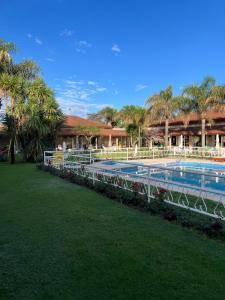 a swimming pool with a resort with palm trees at Garden House Hotel in Río Cuarto