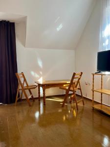a dining room with a wooden table and two chairs at En-Suite Rooms: Novа Guesthouse in Sofia Center in Sofia