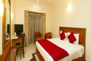 a bedroom with a bed and a desk and a television at Hotel New Ashiyana Palace Varanasi - Fully-Air-Conditioned hotel at prime location With Wifi , Near-Kashi-Vishwanath-Temple, and-Ganga-ghat - Best Hotel in Varanasi in Varanasi