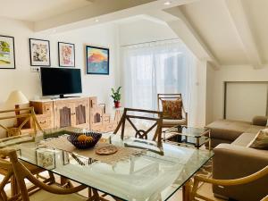 un soggiorno con tavolo in vetro e TV di Apartments Villa Lazic a Petrovac na Moru