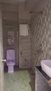 a bathroom with a purple toilet and a sink at Kashi Inn Raj Ghat Varanasi BY GRG in Varanasi