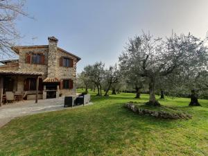 een groot stenen huis met bomen ervoor bij Villa Lisabetta in Montecchio