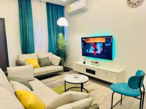a living room with a couch and a tv at CMP APARTMENTS in Kasoa