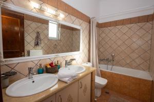 a bathroom with a sink and a toilet and a mirror at John & Angelo Villa in Akrotiri