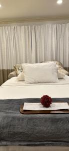 uma cama branca com uma bandeja com uma flor vermelha em Welcoming Private Suite with French Touches em Union